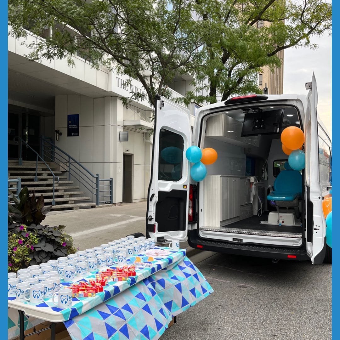 Smile Wagon mobile dental clinic van with table display and balloons in Canada