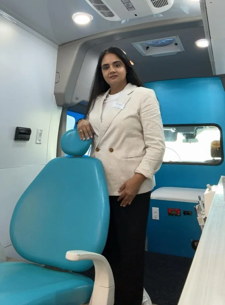 Owner of Smile Wagon standing inside mobile dental hygiene van